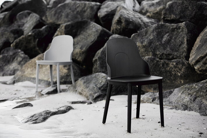 Čierna a biela dizajnová plastová stolička na pláži s kameňmi