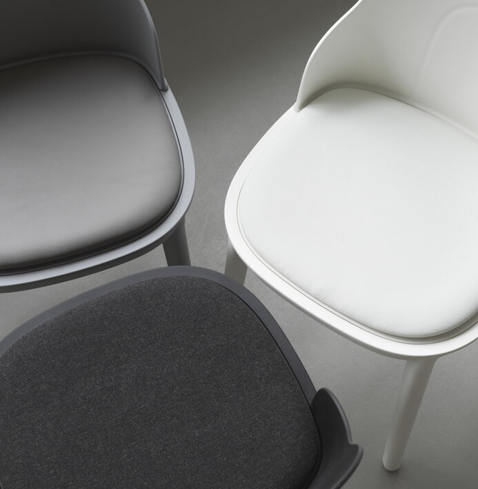 Biela, sivá a čierna stolička z plastu a s koženým čalúnením