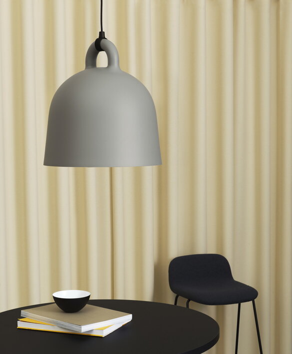 Veľká sivá závesná lampa v tvare zvonu nad stolom v pracovni