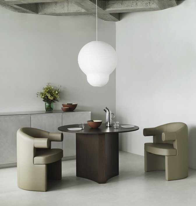 Dve kožené stoličky s podrúčkami v olivovej farbe pri tmavohnedom stolíku 