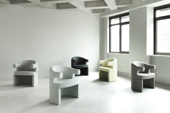 Čalúnené stoličky s podrúčkami v rôznych farbách rozmiestnené v priestore