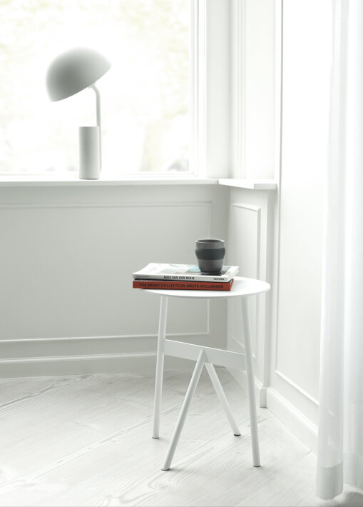 Biela dizajnová stolová lampa s otočným tienidlom na parapete