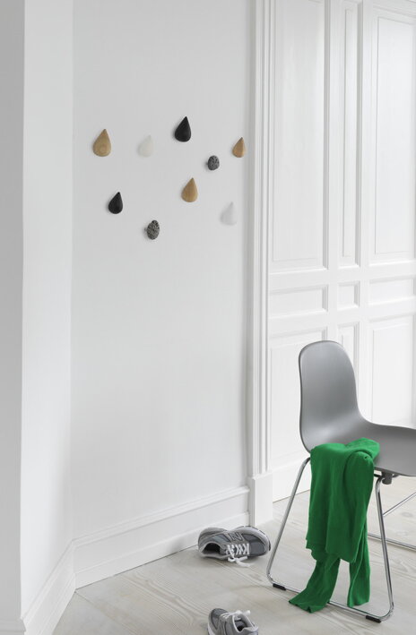 Rôzne dizajnové háčiky Normann Copenhagen na bielej stene v predsieni