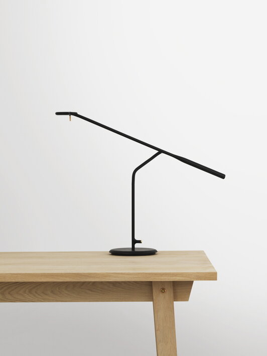 Minimalistická čierna stolová lampa s dlhým ramenom