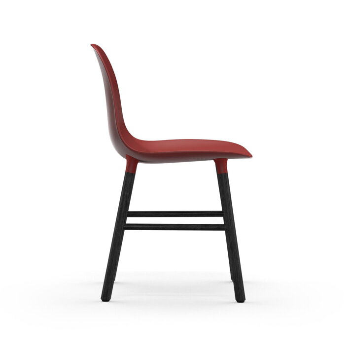 Pohľad zboku na červenú jedálenskú stoličku s čiernymi dubovými nohami