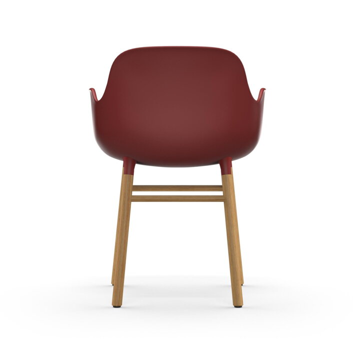 Záber zo zadu na červenú jedálenskú stolička z plastu a s dubovými nohami