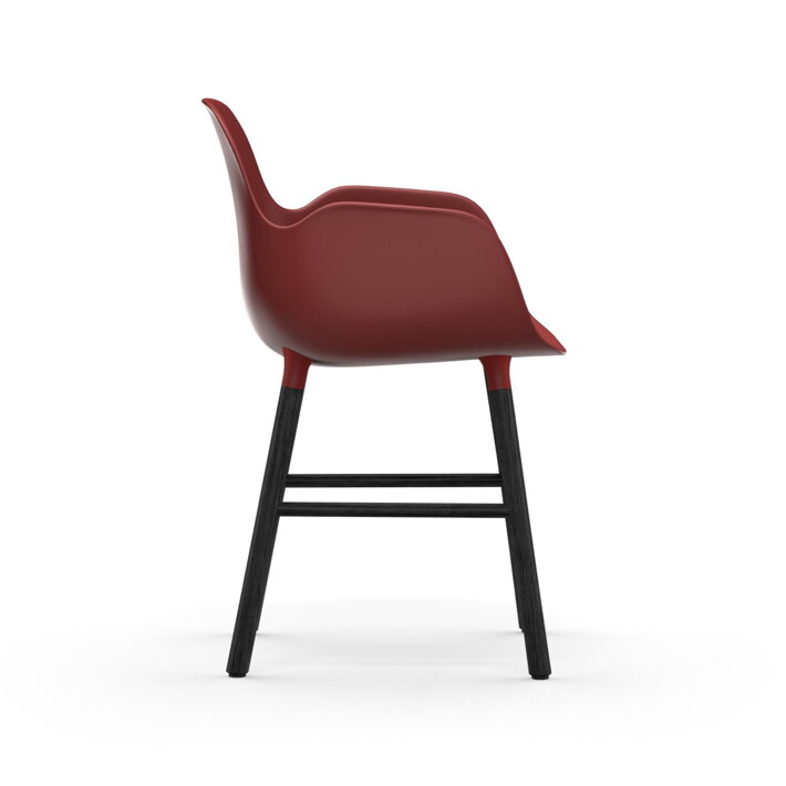 Bočný pohľad na červenú jedálenskú stoličku s podrúčkami a s čiernymi dubovými nohami