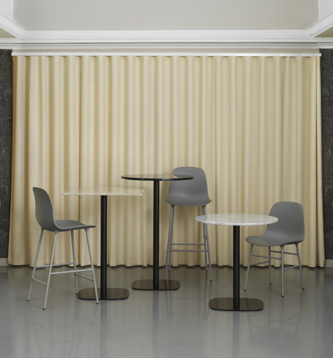 Tri rôzne kaviarenské stoly s troma rôznymi stoličkami s pozadím svetložltého závesu