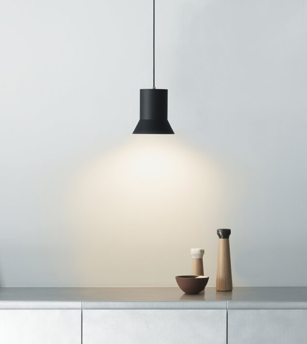 Čierna závesná lampa v tvare klobúka nad kuchynskou linkou