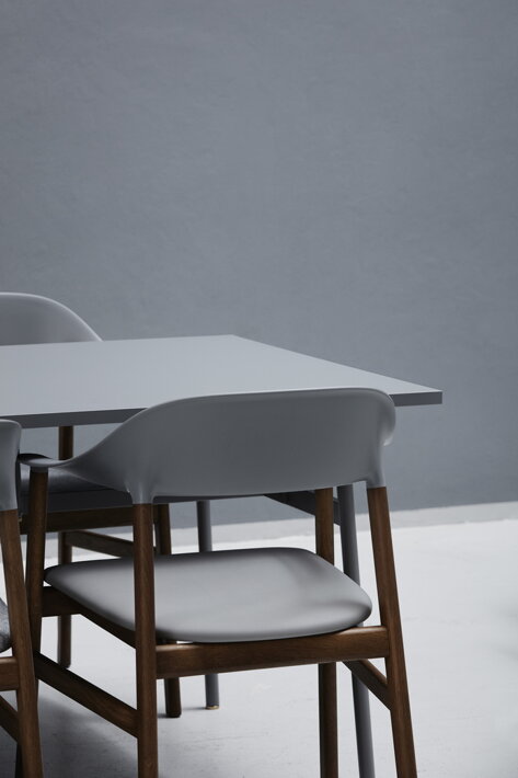 Jedálenská stolička v sivej farbe zasunutá pod sivým stolom