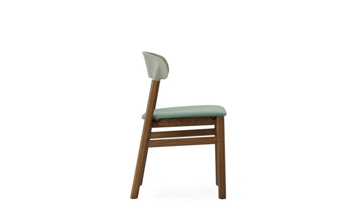 Detail bočnej strany zelenej stoličky s nohami z dymového dubu a s čalúnením
