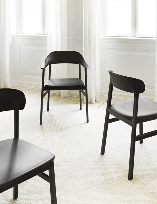 Čierne jedálenské stoličky náhodne rozmiestnené vo svetlej miestnosti