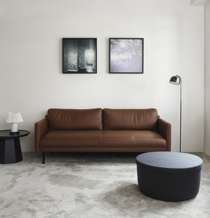 Kožená dizajnová pohovka v hnedej farbe v obývačke s príručným stolíkom