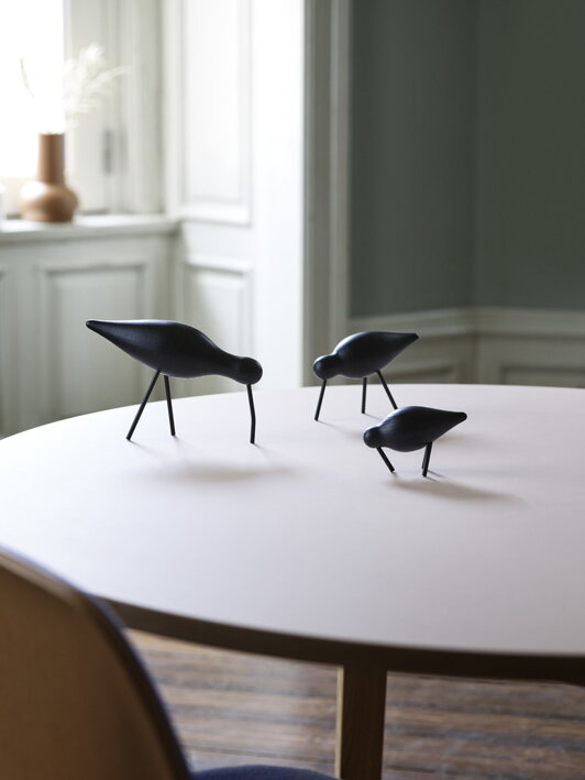 Elegantná figúrka veľkého vtáčika v celočiernom prevedení na jedálenskom stole