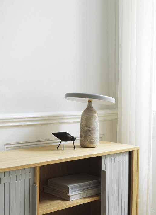 Stredný drevený vtáčik s kovovými nohami v čiernom prevedení pod dizajnovou stolovou lampou