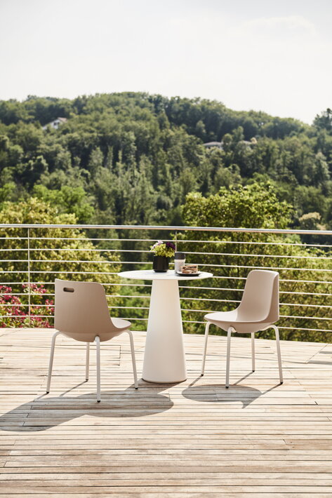 Dve vonkajšie stoličky v pieskovej farbe pri jedálenskom stole na terase