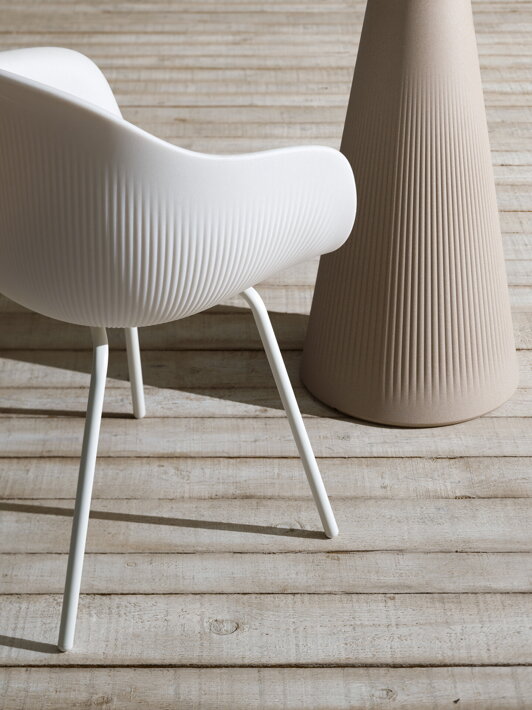 Biela dizajnová stolička z plastu s kovovými nohami na drevenej terase