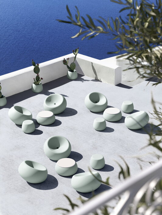Plastový okrúhly stolík na hotelovej terase s kreslami