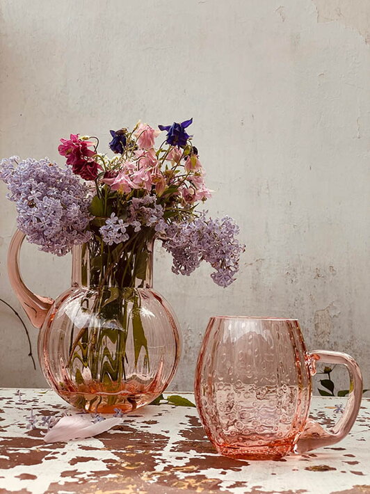 Ručne fúkaný veľký pohár na pivo Slza v ružovej farbe pri váze s kvetmi