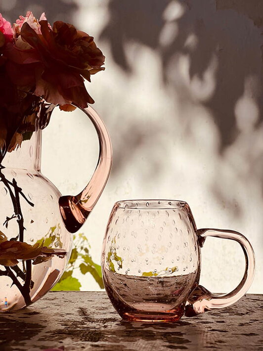 Malý ružový pohár na pivo Slza z ručne fúkaného skla pri váze s kvetmi