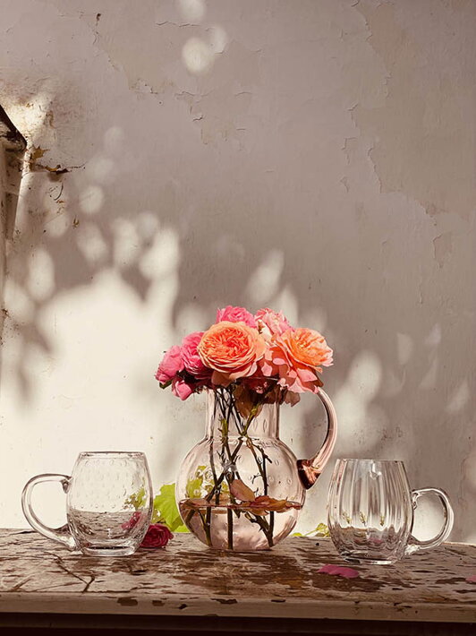 Malé číre poháre na pivo Marie a Slza pri ružovej váze s kvetmi