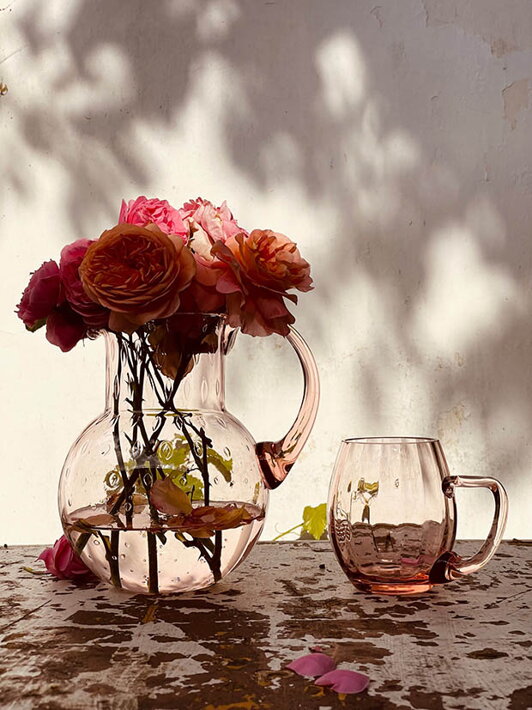 Malý ružový pohár na pivo Marie pri ružovej váze s kvetmi