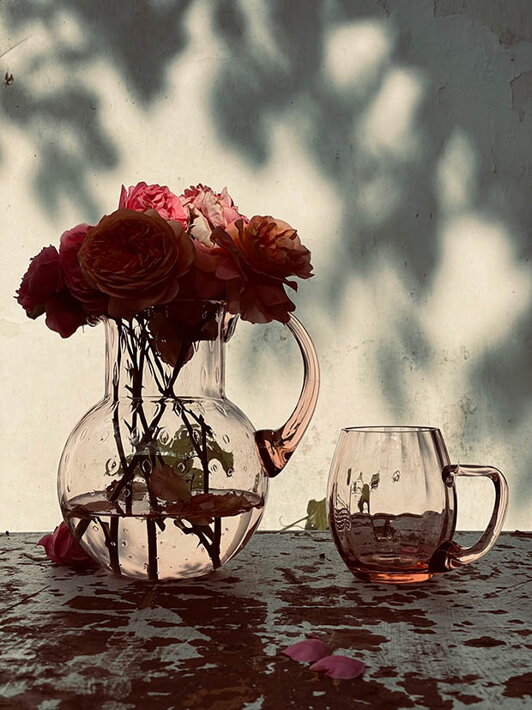 Ručne fúkaný malý pohár na pivo Marie v ružovej farbe pri váze s kvetmi