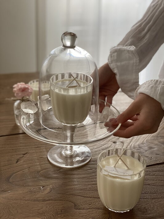Malý číry krištáľový pohár v retro dizajne naplnený vegánskym voskom tvorí vonnú sviečku s vôňou verbena