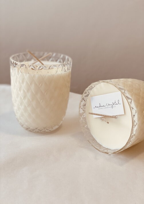 Malý krištáľový pohár s prešívaným efektom naplnený sójovým voskom tvorí vonnú sviečku s vôňou liči a pivoniek