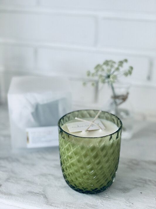 Vonná sviečka "jarná lúka" v zelenom pohári pri dizajnovej vázičke