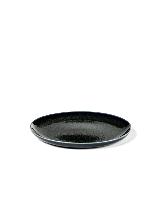 Záber zhora na malý okrúhly tmavomodrý tanier z kameniny so žiarivou glazúrou vhodný ako dezertný tanierik.