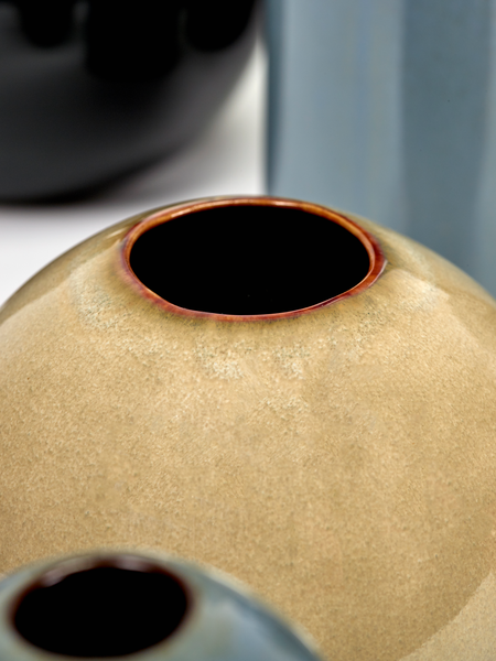 Detailný záber na žiarivú pieskovú glazúru okrúhlej keramickej vázy
