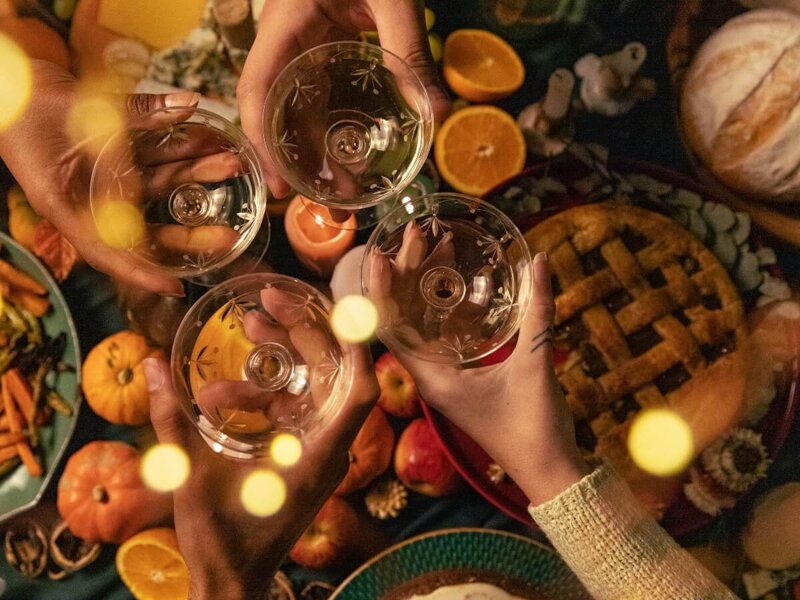 Jesenný stôl plný sezónneho jedla a prípitok s vínom a priateľmi.