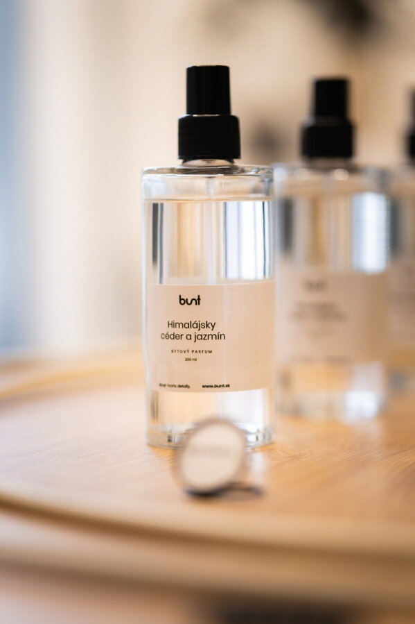 Viacero sklenených fľaštičiek s rozprašovačom naplnené bytovým parfumom s vôňou himalájsky céder a jazmín.