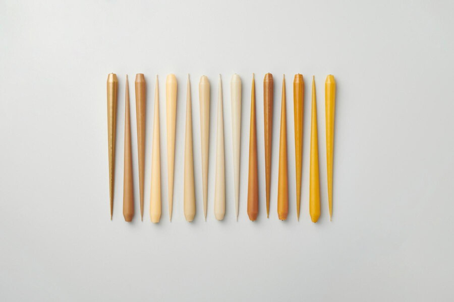 Kónické sviečky Taper v rôznych odtieňoch žltej a béžovej farby.