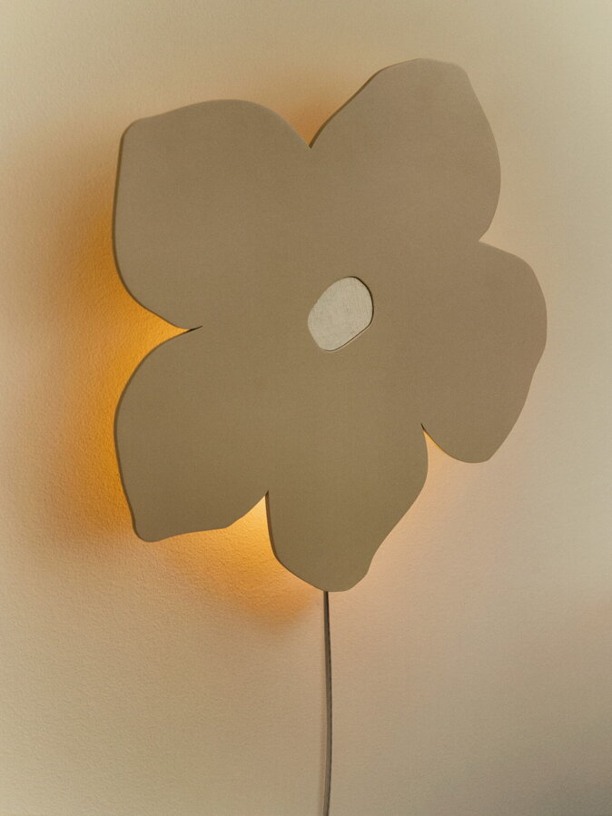 Nástenná zažnutá lampa v tvare kvetu na stene. 