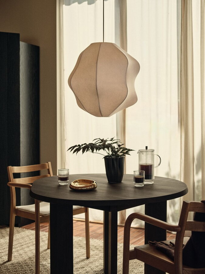 Biele tienidlo na závesnú lampu inšpirované krídlami motýla Peridea nad jedálenským stolom.