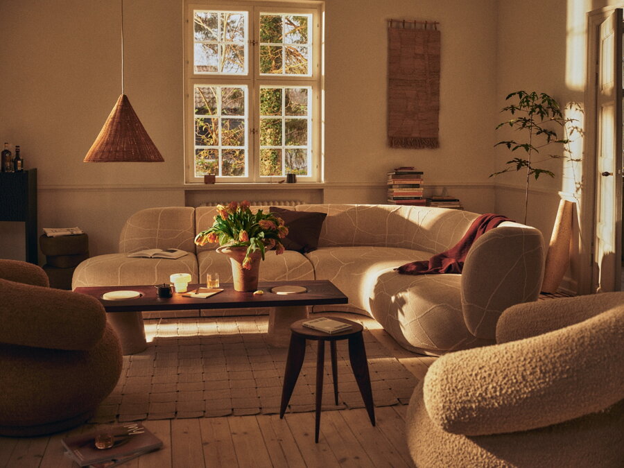 Luxusný konferenčný stolík s obdĺžnikovou stolovou doskou, vyrobený z travertínu a karbonizovaného jaseňa, v obývačke.