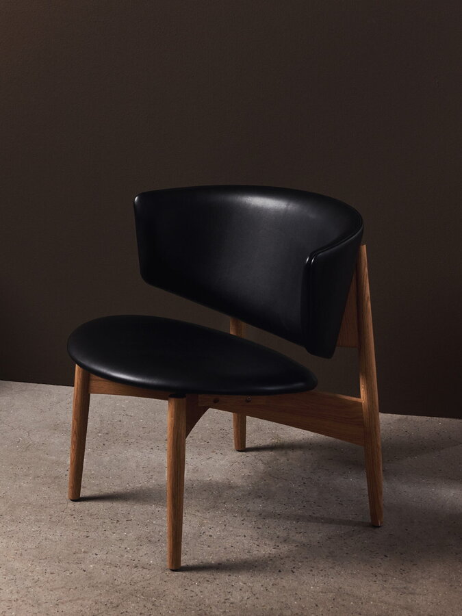 Stolička Herman Lounge Chair Vegea s dubovým rámom a čiernym čalúnením Vegea.