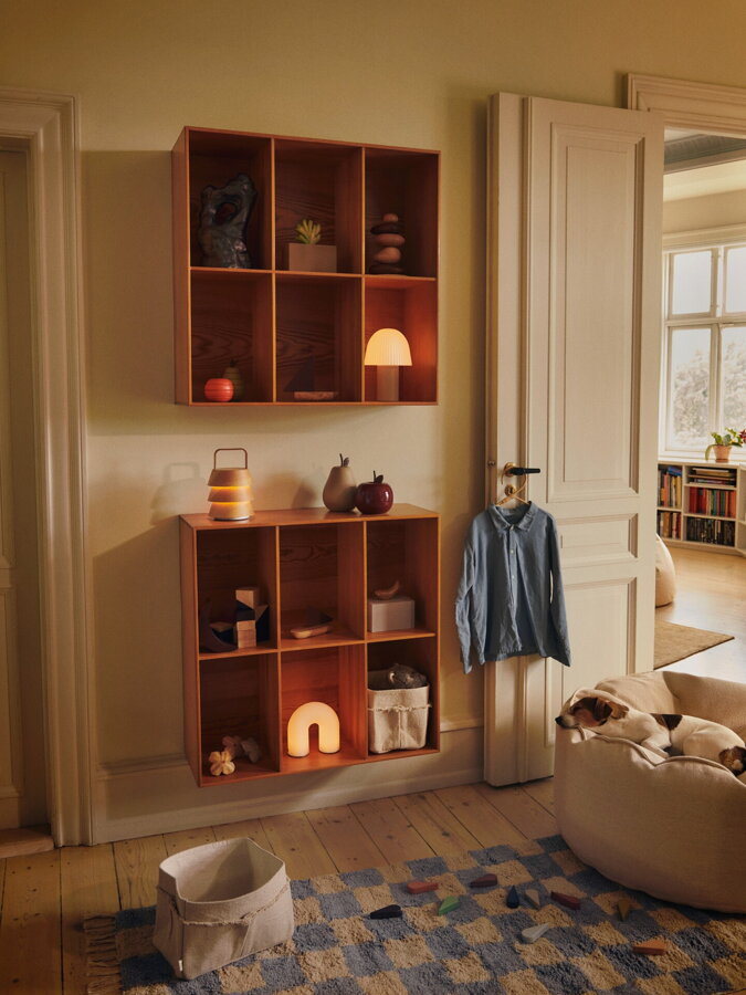 Svetlomodrý károvaný koberec z bavlny a so strapcami v detskej izbe, kde v bielom kresle sedí pes.