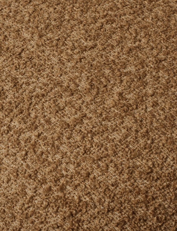 Vzorka hnedej tkaniny Raw Bouclé, ktorou je kreslo Orbo čalúnené.