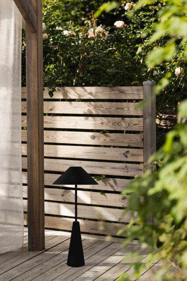 Čierna prenosná stojanová lampa na terase v nastavenej najnižšej výške.