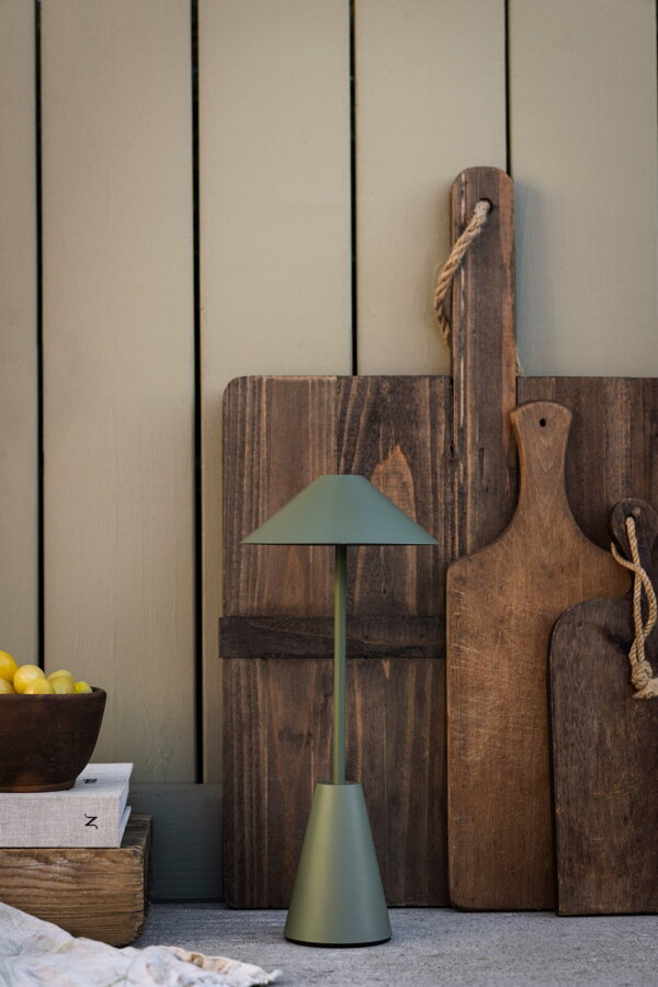 Zelená prenosná stolová lampa na kuchynskej linke.