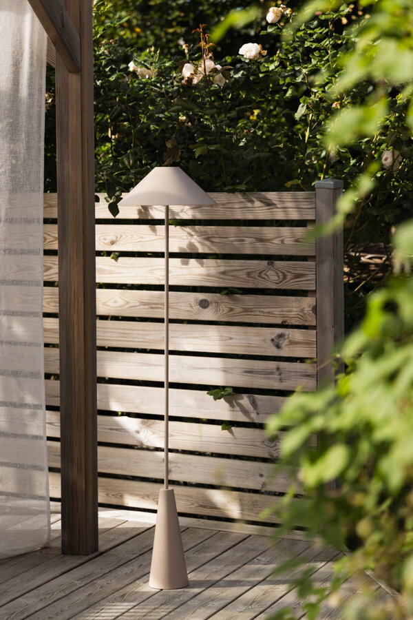 Hnedosivá prenosná stojanová lampa na terase.