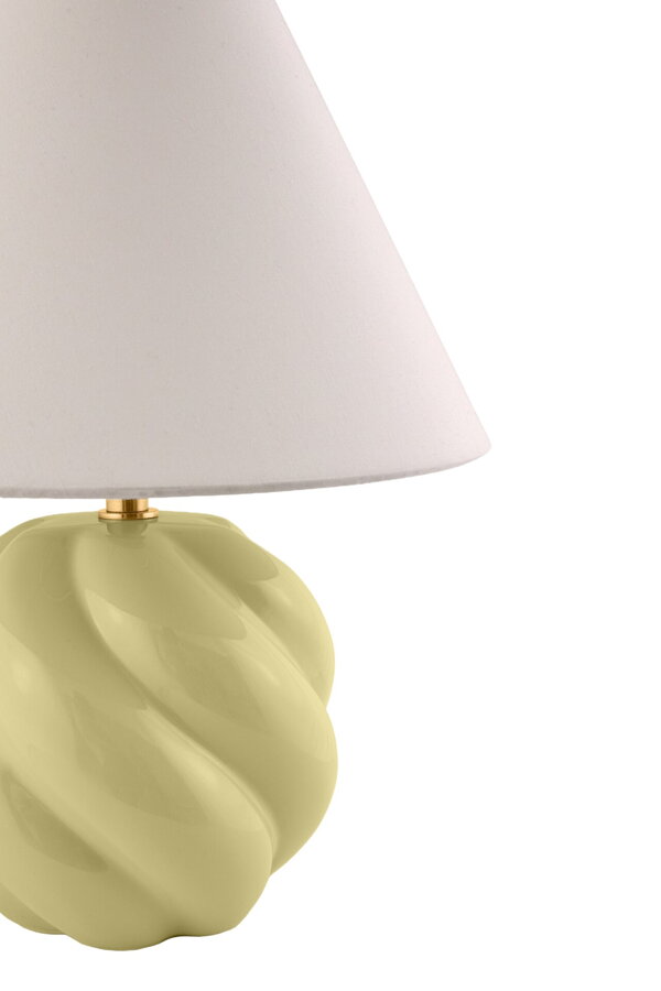 Stolová lampa Dahlia lesklou keramickáou základňou s unikátnou vlnitou textúrou a elegantným bavlneným tienidlom svetložltej farby.