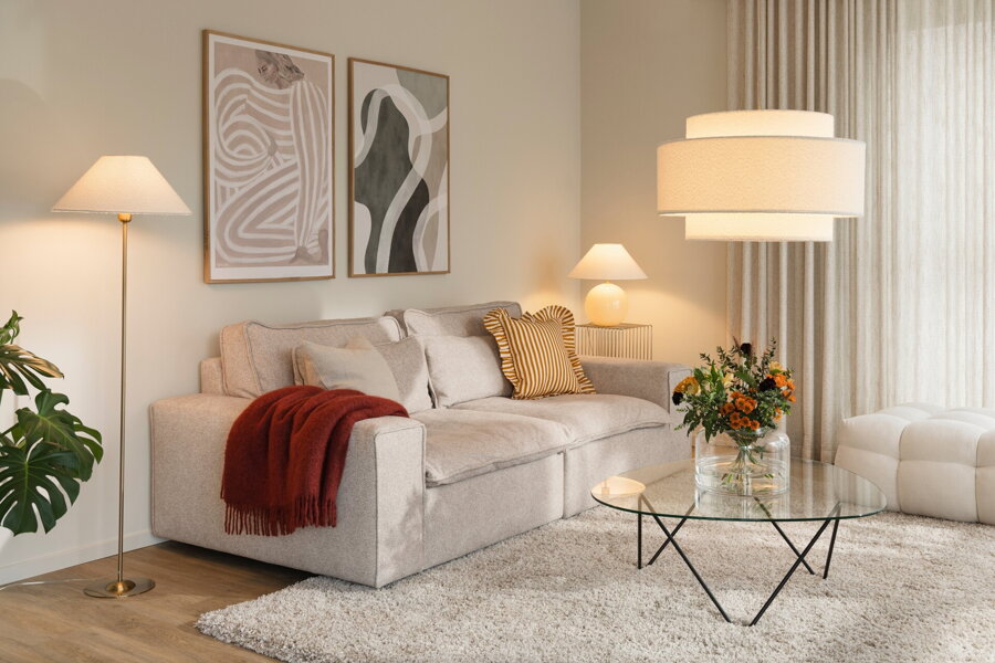 Svietiaca kovová stojanová lampa s béžovým textilným tienidlom vedľa v obývačke s ďalšími svietidlami Iris.