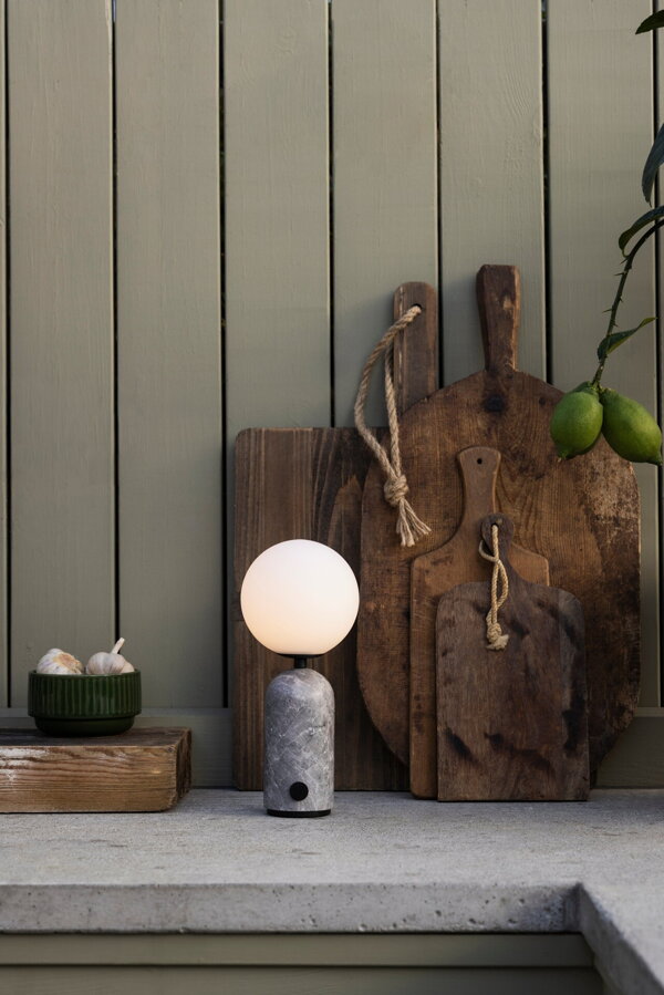 Stolová lampa Torrano s masívnou sivou mramorovou základňou a s jemným tienidlom z bieleho opálového skla na kuchynskej linke.