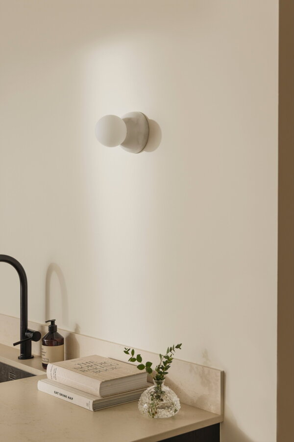 Nástenná lampa Torrano s maso bielou mramorovou základňou a s jemným tienidlom z bieleho opálového skla.