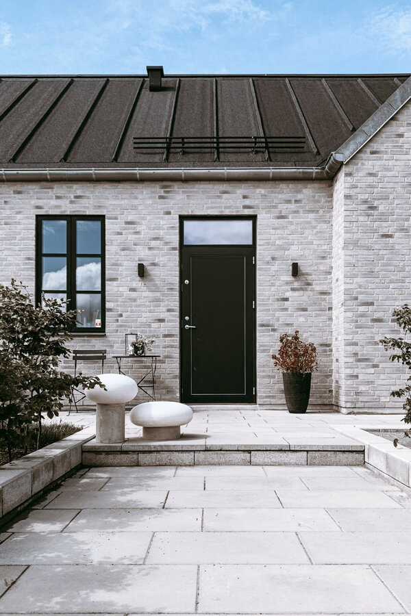 Dve sivé exteriérové stojanové lampy Umfors pred domom.