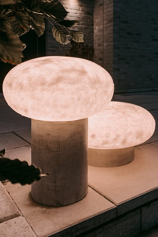 Rozsvietené sivé exteriérové stojanové lampy Umfors vo večernej atmosfére.